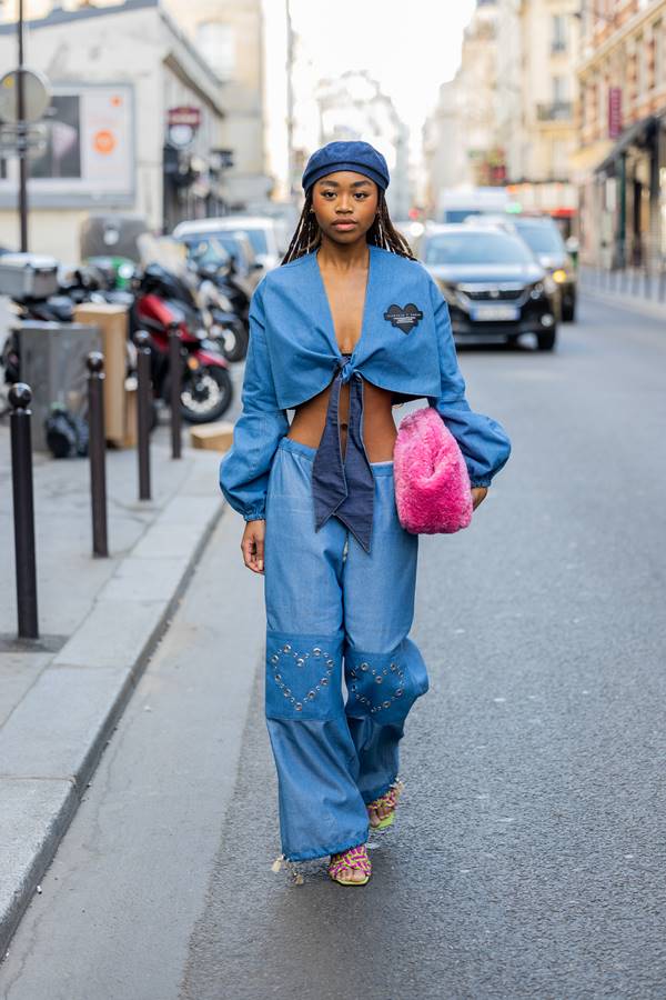 Mulher usa look jeans de cintura baixa com boina, além de bolsa rosa felpuda - Metrópoles