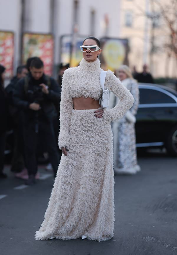 Mulher usa look branco de pelinhos com saia longa e cropped de gola alta - Metrópoles