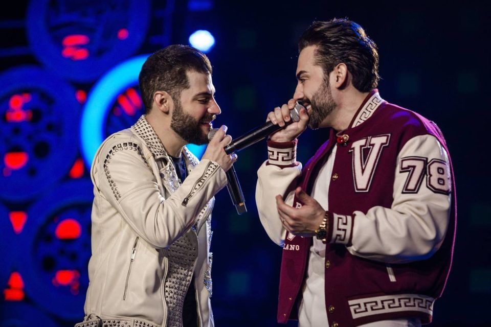 Foto colorida dos cantores Guilherme e Benuto em gravação de novo DVD