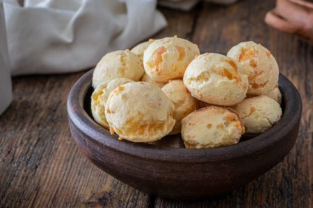 pão de queijo vegano dentro de uma cuba marrom apoiada na mesa - metrópoles