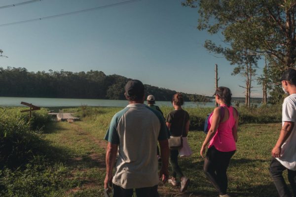 Imagem colorida de pessoas em um parque olhando um lago