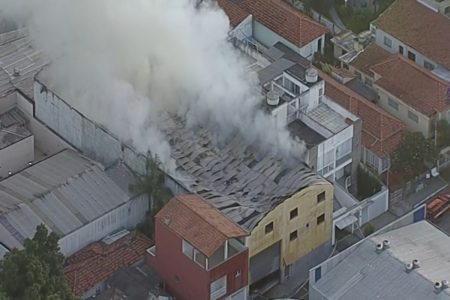 Imagem colorida de um prédio pegando fogo e com muita fumaça