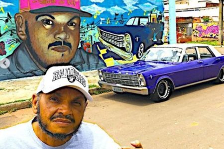 Dj Jamaika em frente a um carro azul - Metrópoles