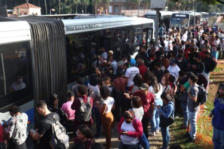 Imagem colorida de pessoas pegando ônibus