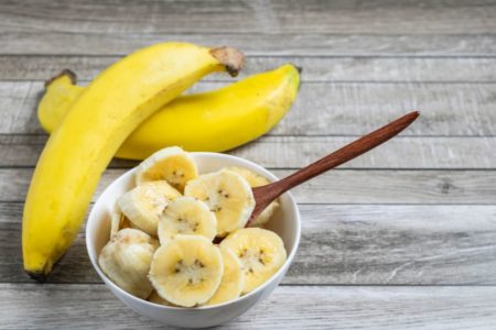 Bananas picadas em uma travesa branca com uma colher de pau dentro - Metrópoles