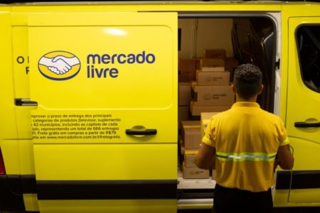 Entregador coloca caixa dentro de van estilizada com o logo do Mercado Livre