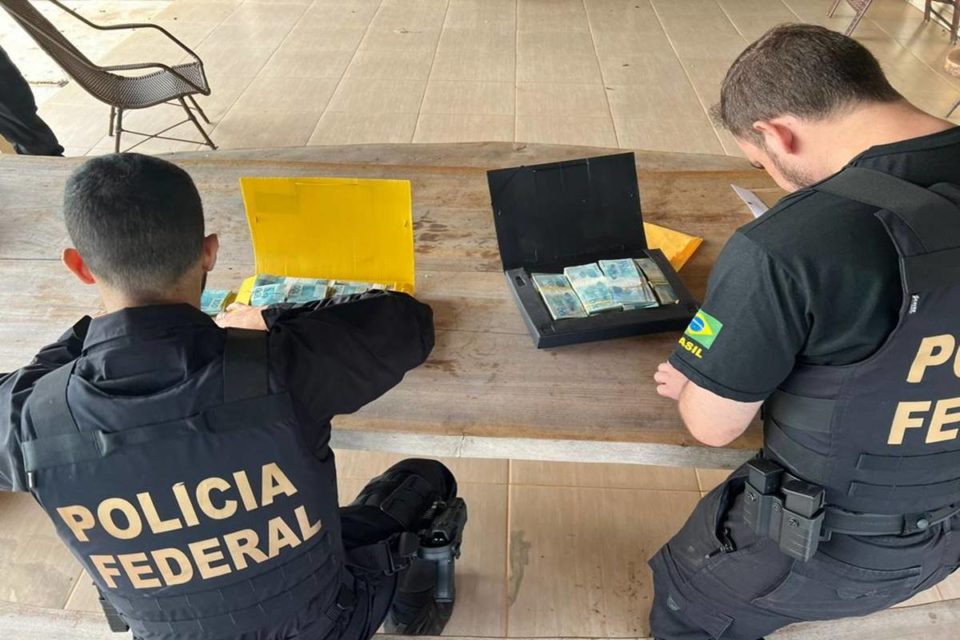 Policiais contam notas de dinheiro dentro de maleta