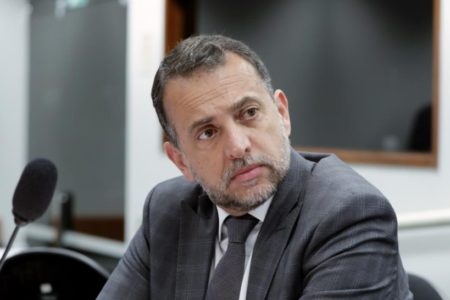 Fotografia colorida de Marco Bertaiolli, homem branco de cabelo e barba grisalhos, com a cabeça levemente inclinada para a esquerda - Metrópoles