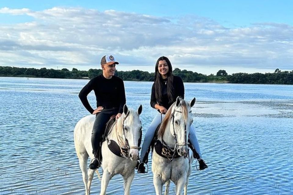 Foto colorida de João Gomes e Ary Mirelle andando a cavalo