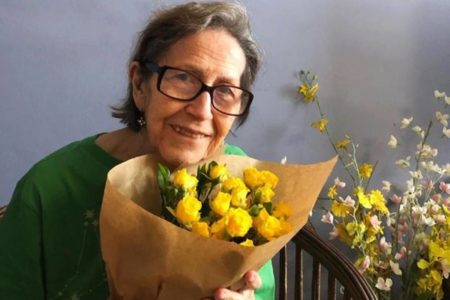 rosto de mulher idosa usando oculos com buque de flores amarelas logo abaixo - metrópoles