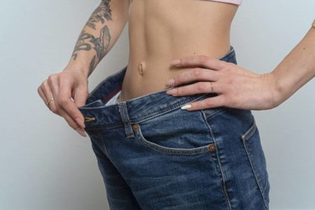 Calça larga sobrando no quadril de mulher com barriga "seca"