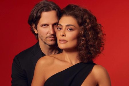 Juliana Paes e Vladimir Brichta posam de roupa preta em frente a fundo vermelho - metrópoles