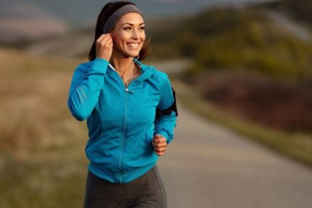 Mulher fazendo corrida em uma estrada com uma camisa azul - Metrópoles