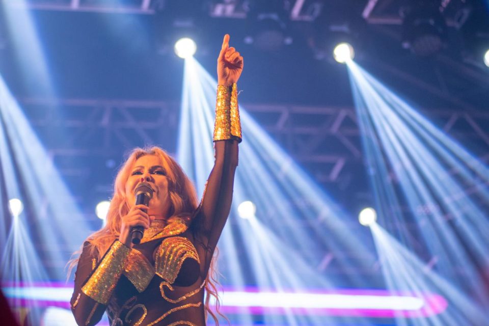 Foto colorida de Joelma durante show em Brasília. Ela está usando uma roupa escura - Metrópoles