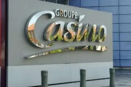 Imagem do logotipo do grupo francês Casino, em uma placa em frente a um prédio