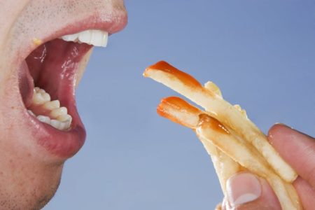 Foto de homem que come batata frita com katchup - Metrópoles