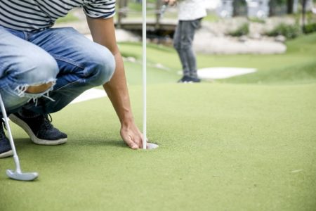 Homem se agacha durante partida de golf - Metrópoles