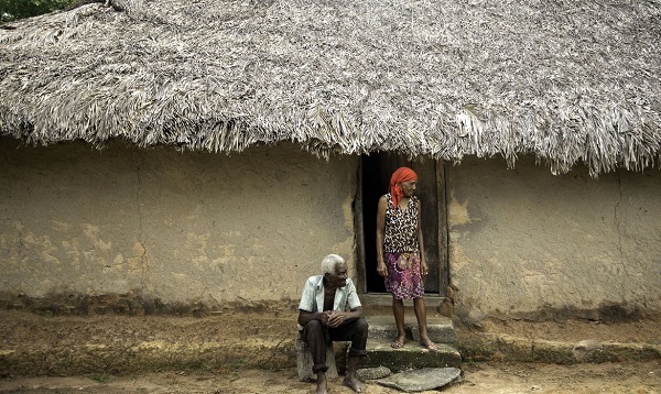imagem colorida com um casal de quilombolas em frente a uma casa de palha - Metrópoles