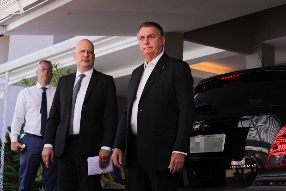 Jair Bolsonaro e o advogado Marcelo Bessa em garagem de casa com carro ao fundo