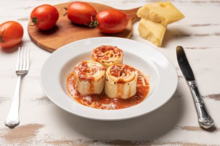 Rondelli de tomate em um prato branco com tomates soltos em volta -Metrópoles