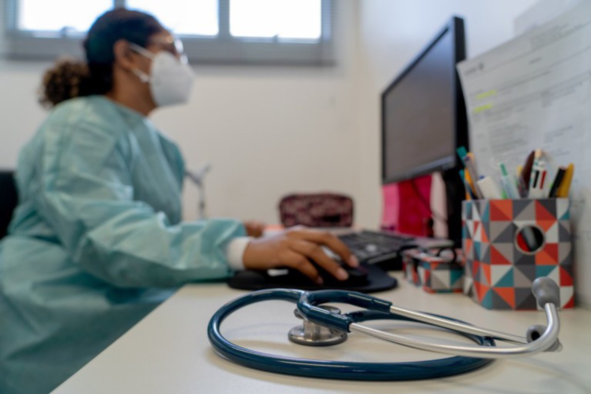 Fotografia colorida mostrando médica mexendo em computador-Metrópoles