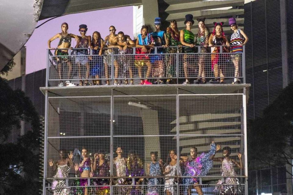 Modelos usando roupas coloridas em cima de um andaime no centro de São Paulo - Metrópoles