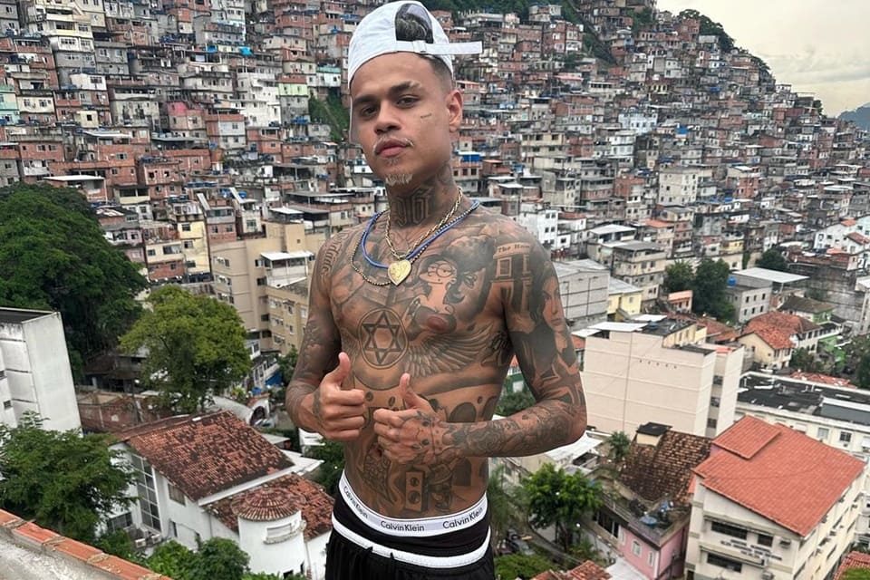 MC Cabelinho usando boné e fazendo joia - Metrópoles