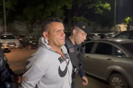 Homem de casaco cinza é levado por policiais