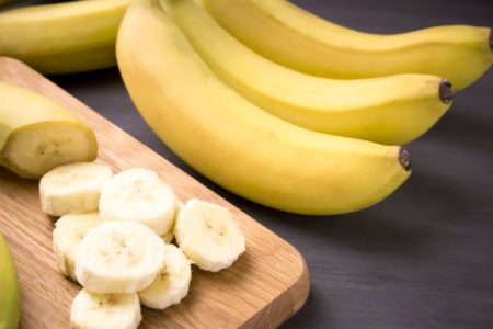 Banana cortada e interira em cima da mesa