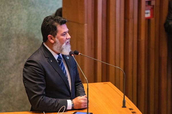 Fotografia colorida de homem de terno e barba branca em púlpito