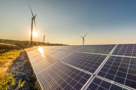 Foto colorida de placas de energia solar e estações de energia eólica - Metrópoles