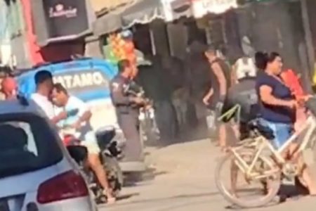 Foto colorida do momento em que um policial militar atira contra um homem em Macaé, no Rio de Janeiro - Metrópoles