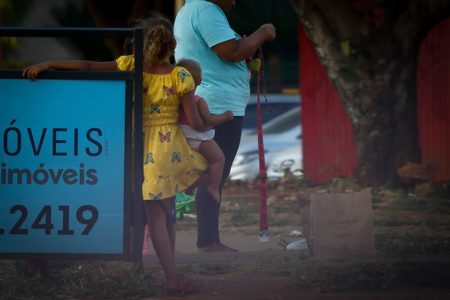 Mãe ao lado de crianças na rua próximo a semáforo na Asa Norte no Plano Piloto. Conscientização contra o trabalho infantil