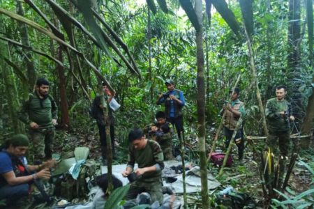 Imagem colorida mostra Resgate de crianças em selva na Colômbia. Além das crianças, aparecem militares - Metrópoles