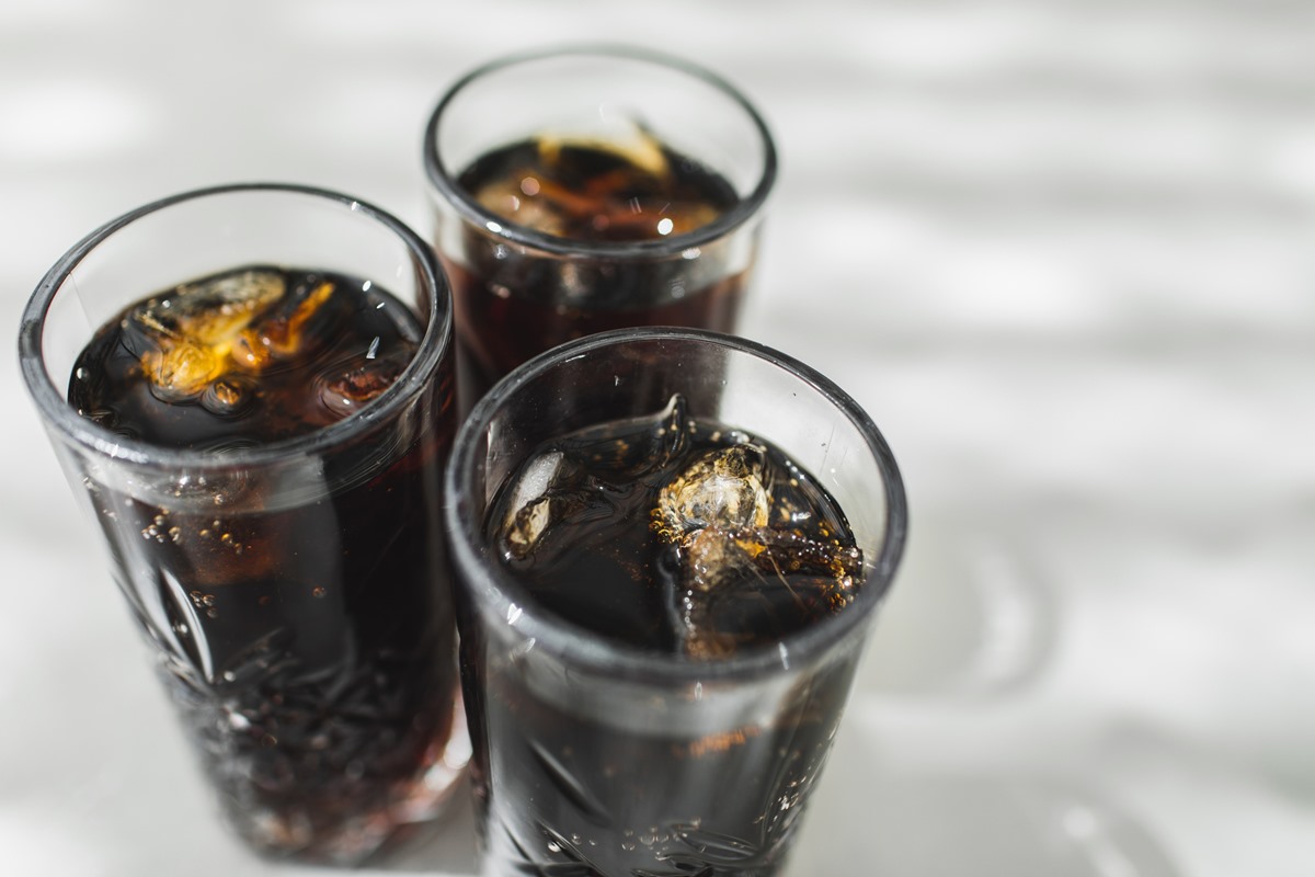 Foto colorida de três copos transparentes com coca e gelo dentro - Metrópoles