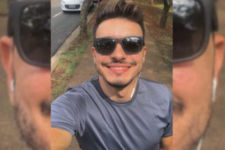 foto colorida mostra jovem Bruno Teixeira sorrindo, com óculos escuros e camiseta azul - Metropoles