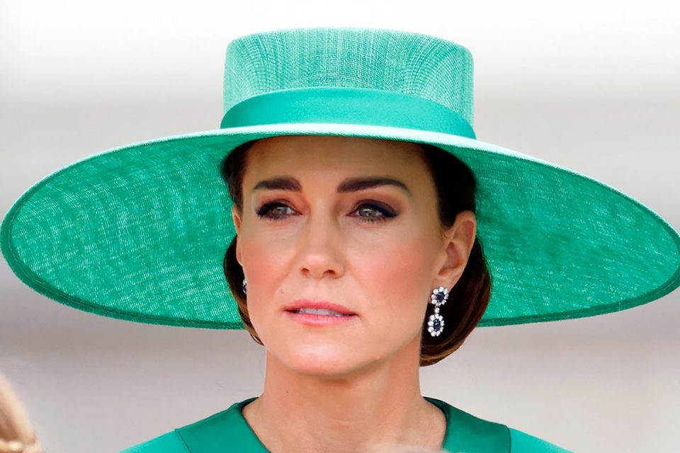 Foto colorida de mulher branca, com cabelo castanho amarrado, usando roupa e um chapéu verde - Metrópoles
