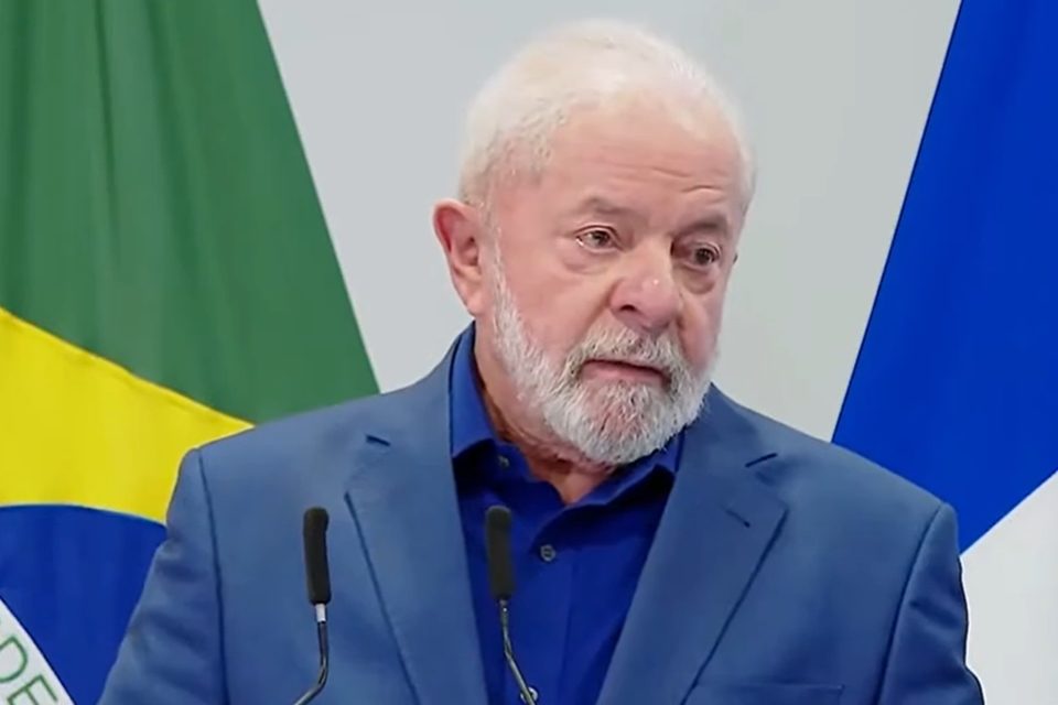 Imagem colorida com bandeira do Brasil do presidente Luiz Inácio Lula da Silva em coletiva na França