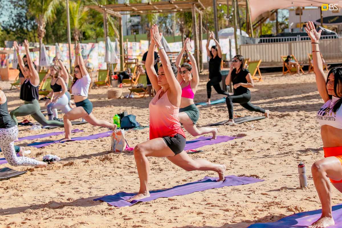 Fotografia colorida mostrando pessoas fazendo alongamento no parque Na Praia-Metrópoles