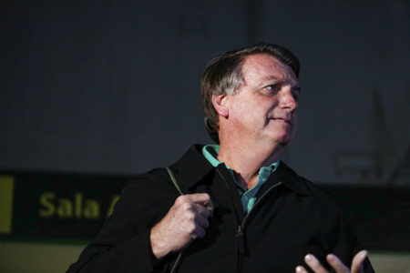 Imagem colorida mostra o ex-presidente Jair Bolsonaro, um homem branco de cabelos castanhos um pouco grisalhos, de perfil, vestido com uma blusa preta e uma camisa verde - Metrópoles