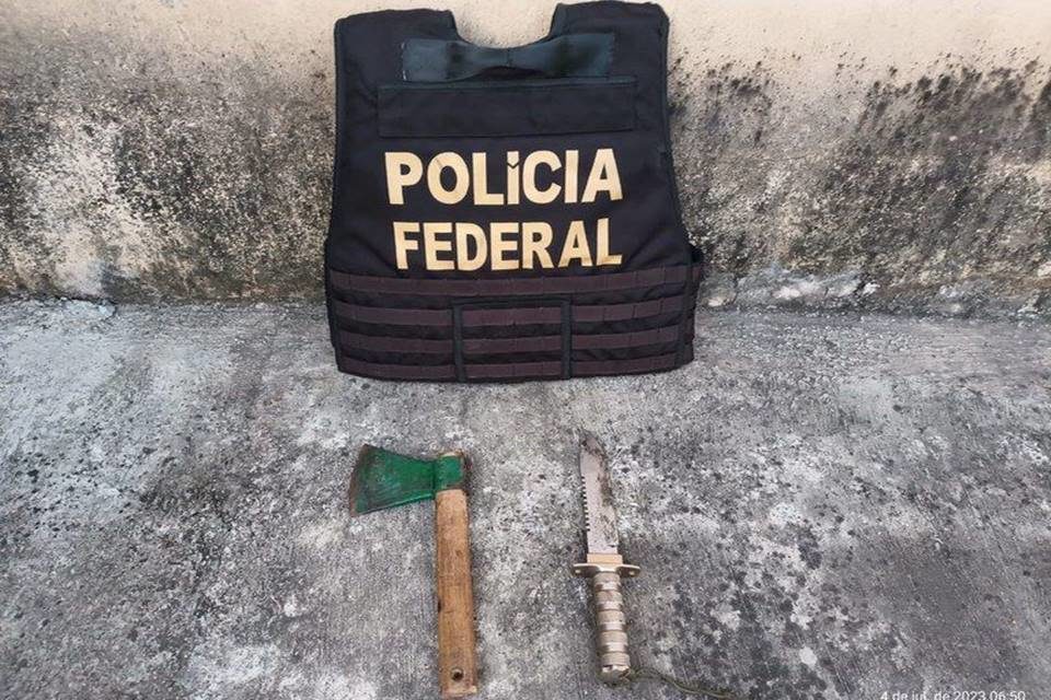 Colete ao lado de machado e faca