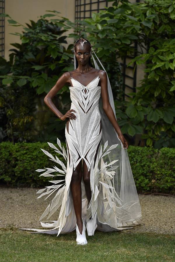 Em fundo verde, modelo usa vestido branco - Metrópoles