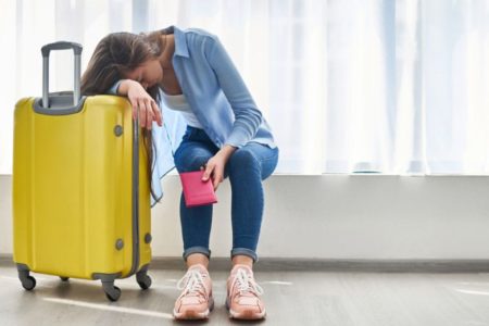 moça com mala amarela esperando jet-lag