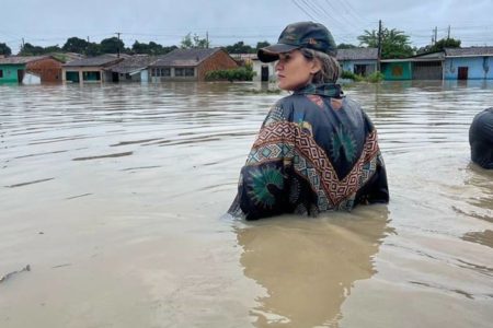 mulher de costas posa olhando de lado com agua suja até a cintura - metrópoles