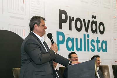 Imagem colorida de Tarcísio de Freitas de perfil segurando um microfone - Metrópoles