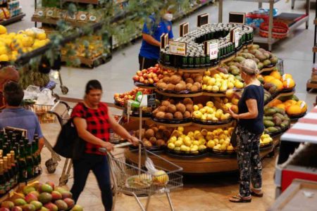 Mulher caminha com carrinho em supermercado - Metrópoles