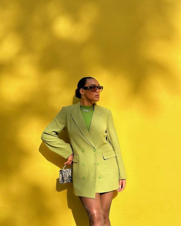 Na imagem com cor, uma mulher negra usando um blazer verde neon - Metrópoles