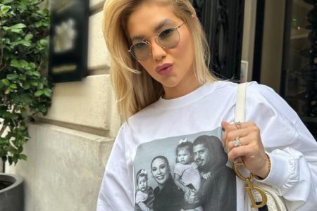 Virginia Fonseca com óculos escuros, bolsa e blusa com a foto da família - Metrópoles