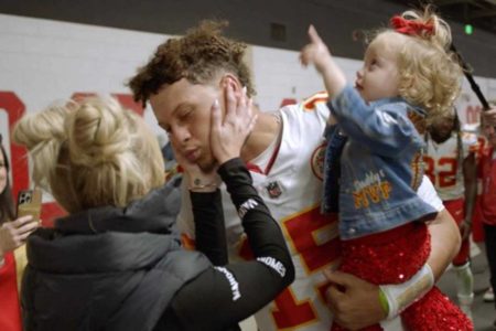 Imagem colorida de um homem branco, segurando uma menina loira e recebendo carinho uma mulher loira. Cenas da série Quarterback, da Netflix - Metrópoles