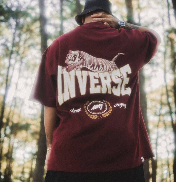 Na imagem com cor, modelo posa com camiseta com logo escrita Inverse - Metrópoles 